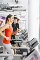 Group of young people using treadmills in a gym photo