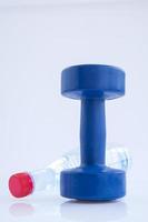 Blue plastic coated dumbells And Water Bottle isolated on white photo