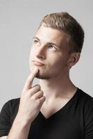 portrait of thoughtful young caucasian man isolated on gray background photo