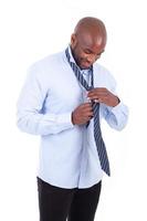 hombre de negocios afroamericano anudando una corbata foto