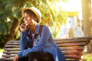 Cheerful young african american woman sitting outside photo