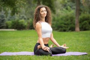 Pretty woman doing yoga meditation in the lotus position photo
