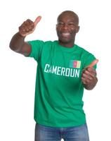 Aficionado a los deportes riendo de Camerún mostrando ambos pulgares arriba