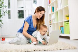 Young attractive mother and baby using computer photo
