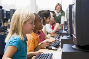 Kindergarten children learning how to use computers photo