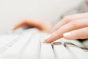 manos femeninas escribiendo en el teclado comuter foto