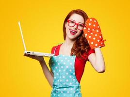 Young housewife with computer and oven gloves