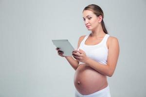 Retrato de una embarazada usando tableta