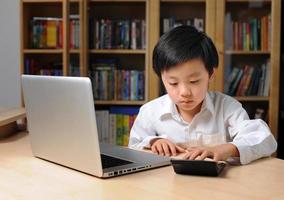 Asian boy in front of laptop computer