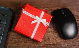 composición con caja de regalo roja, mouse y teclado foto
