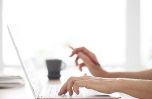 primer plano de manos de mujer en el teclado de la computadora foto