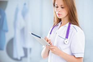 beautiful young female medical intern with tablet computer