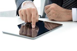 Businessman hand touching tablet computer on the table