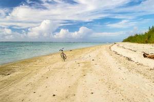 Bicicleta de empuje solitario en una playa desierta tropical