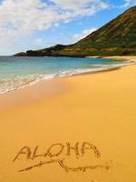 Mensaje de "aloha" en arena en playa hawaiana
