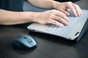 Hombre usando laptop con teclado blanco. trabajando en la oficina