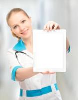 Doctor mujer sosteniendo una tableta blanca en blanco