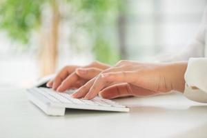 manos de una mujer de oficina escribiendo teclado con tarjeta de crédito
