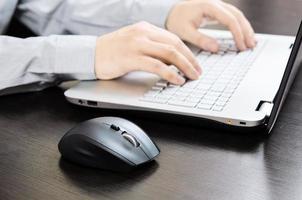 Hombre usando laptop con teclado blanco. trabajando en la oficina
