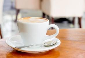 taza de café con leche en el escritorio de madera