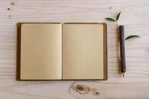 Recycle notebook with wooden pencil on wooden desk