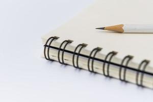 white pencil with blank notebook photo
