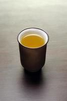 one chinese tea cup on wooden table with tea photo