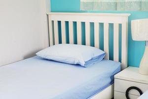 light blue pillow on white  bed in bedroom photo