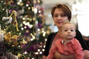 familia posando junto al árbol de navidad foto
