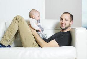 padre con bebé en el sofá tomando buen tiempo foto