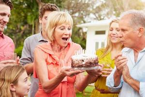 Familia multigeneración celebrando cumpleaños en jardín foto