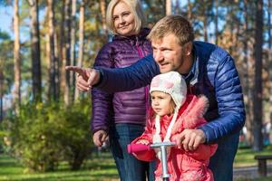 Young Family in Autumnal Forest Pointing photo