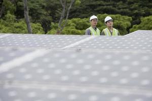 dos ingenieros asiáticos en una estación de paneles solares