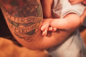 bebé recién nacido en manos del padre foto