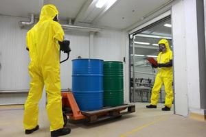 Dos trabajadores que trabajan con barriles de productos químicos en la fábrica. foto