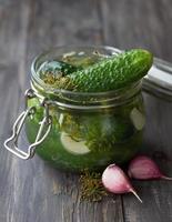 Glass jar of fresh low-salt pickled cucumbers photo