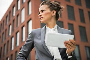 mujer de negocios con tablet pc frente a edificio de oficinas