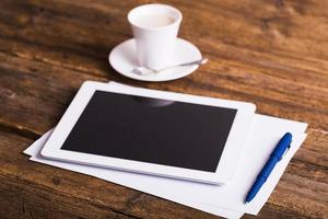 tableta digital y café sobre fondo de madera vieja