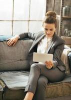 Business woman in loft apartment and using tablet pc