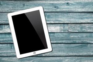 Tablet pc on wooden background photo