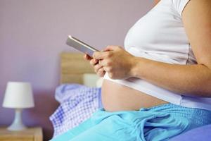 mujer embarazada con tableta foto