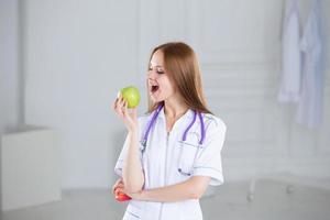 Doctor biting a green apple.