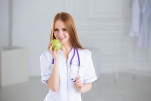 Doctor sosteniendo una manzana verde. concepto de comida saludable. foto