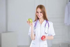 Doctor holding a green apple. Concept of healthy food.