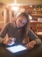 Mujer con tablet pc y stylus en cafe foto