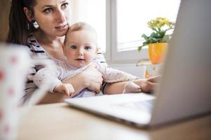 A young mother and her baby working from home