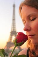 Woman smelling rose in Paris photo