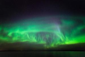aurora boreal sobre el lago en Finlandia foto