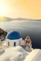 Reflecting sun on a blue dome in Oia photo