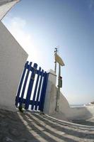 Blue fence and white wall in oia of santorini